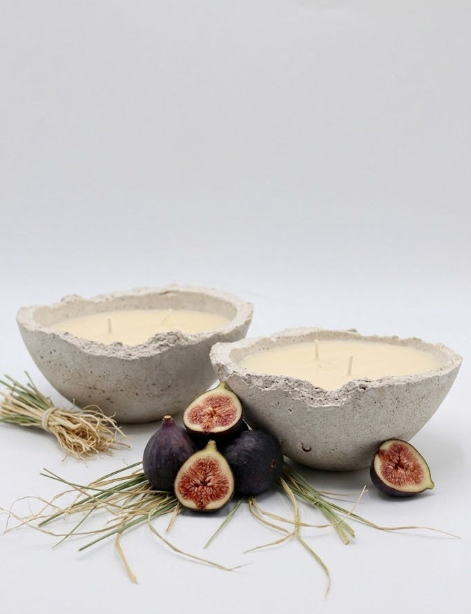 Two concrete bowls with candles and figs on a white background