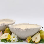 Ceramic bowl with pears and flowers on a white background