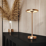 Gold cordless table lamp on a black console