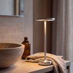 Silver cordless lamp on a limestone bathroom vanity