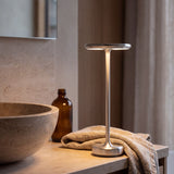 Silver cordless lamp on a limestone bathroom vanity
