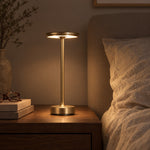 Gold cordless lamp on a walnut nightstand at night
