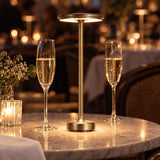 Gold cordless lamp on a restaurant table with champagne