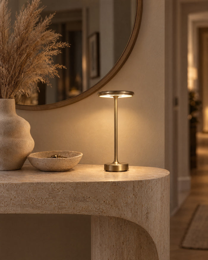Gold cordless lamp on a travertine hallway console